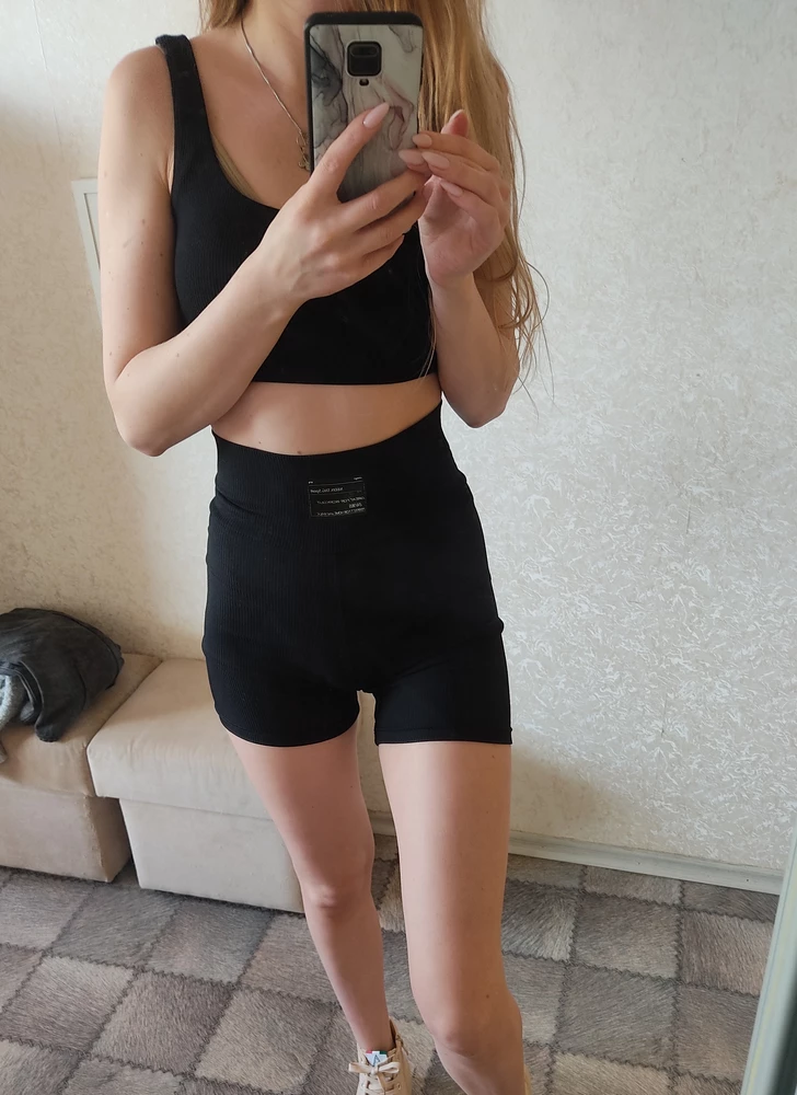 Костюм очень понравился,  идёт в размер, качество очень хорошее тоненький,  мягкий к телу,  очень комфортно для спорта и прогулок.
Если бы меня спросили, то эмблему бы я предпочла видеть на топе спереди.
Есть чашечки, комфортная синтетика, но так и нужно для спорта, кататься точно не будет))
Швы очень крепкие, шорты не длинные, самое оно ☺️☺️